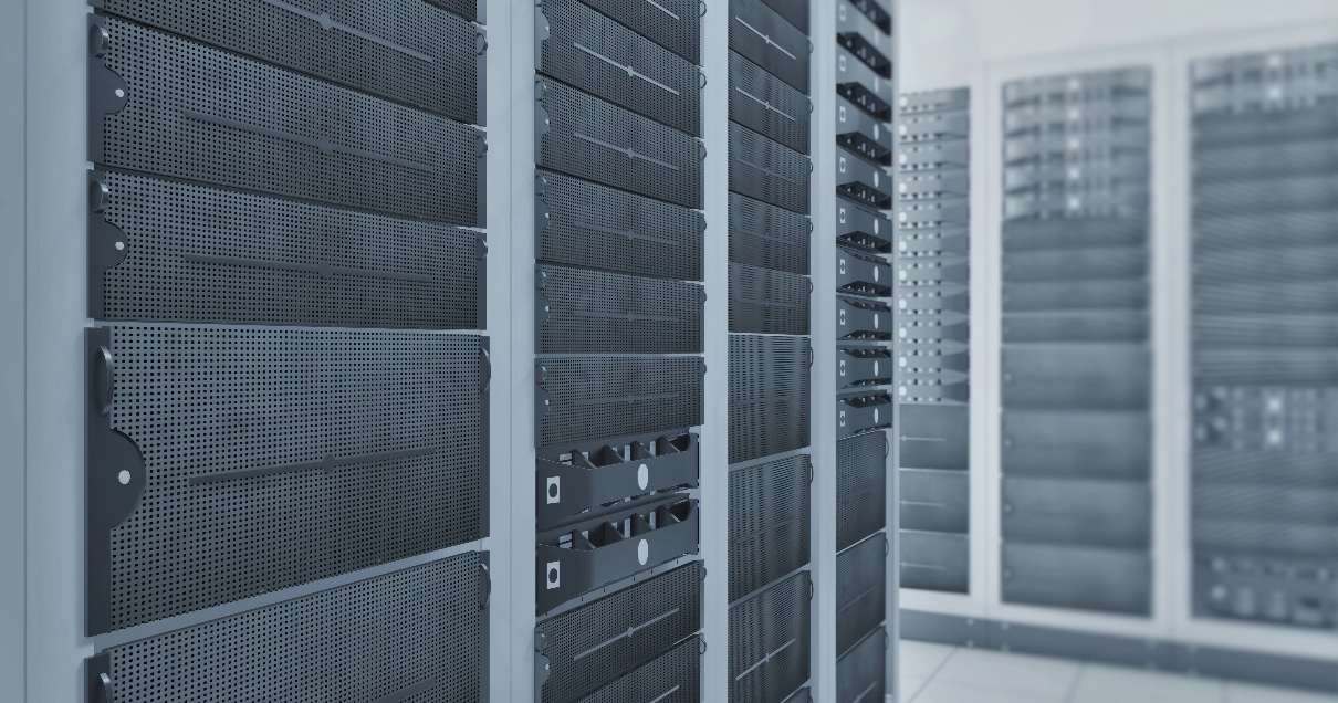 Gray server racks in a datacenter; clean and monochrome.
